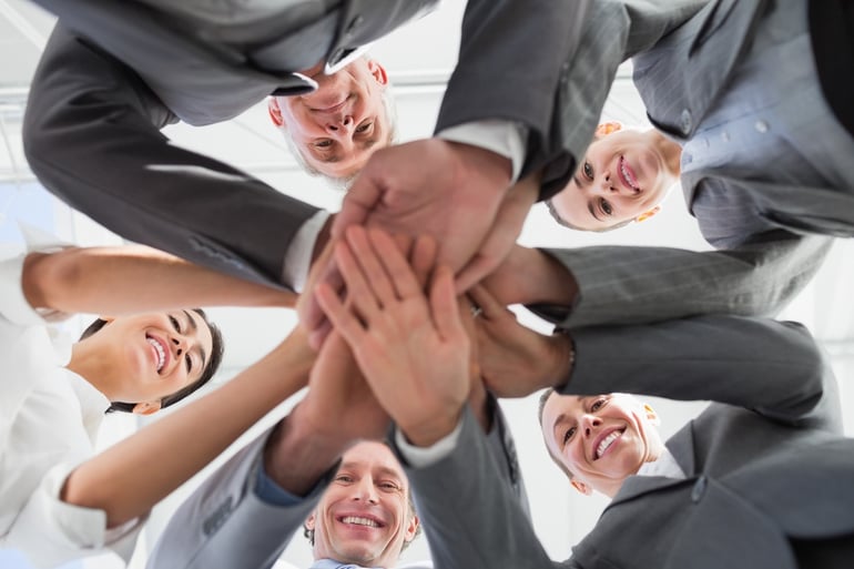 Business team standing hands together in the office.jpeg