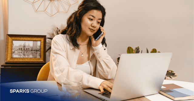 female using laptop while on mobile phone